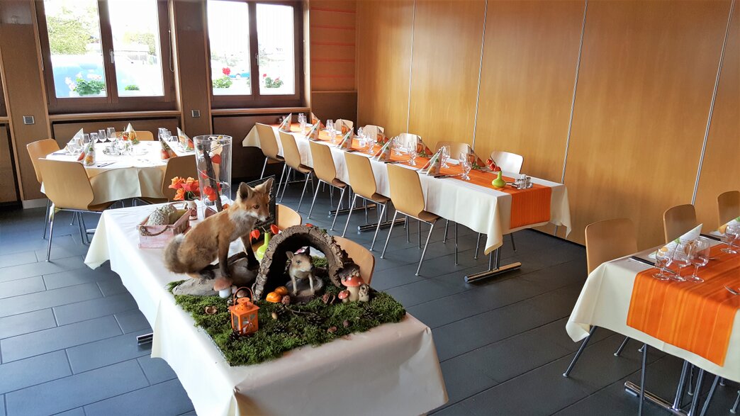 Peitte salle préparée avec tables dressées et chaises pour les menus proposés pendant la période de chasse du restaurant Maison de Ville à Vuippens